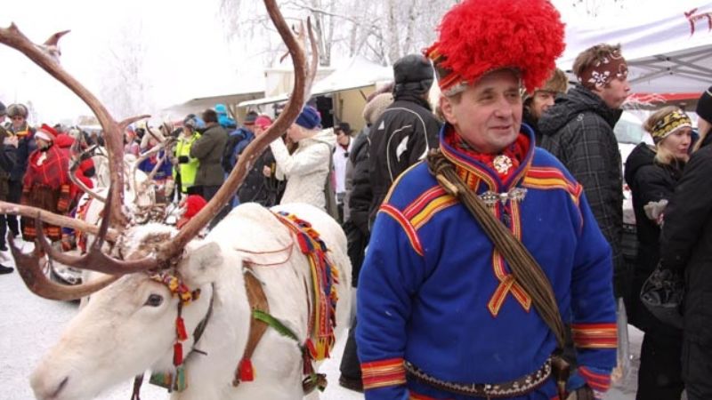 Jokkmokks marknad med same i dr�kt och vit ren under vinterfirande - bussresor Sverige.